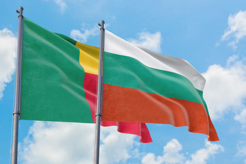 Bulgaria and Benin flags waving in the wind against white cloudy blue sky together. Diplomacy...