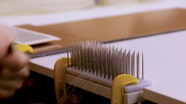 Hair combing when creating a wig. Factory wig production process