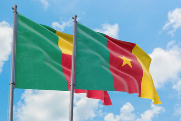 Cameroon and Benin flags waving in the wind against white cloudy blue sky together. Diplomacy concept, international relations.