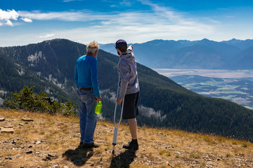 Two friends discussing flight plan on hang glider. A beautiful hilltop landscape. Extremal hikers...