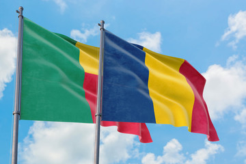Chad and Benin flags waving in the wind against white cloudy blue sky together. Diplomacy concept, international relations.