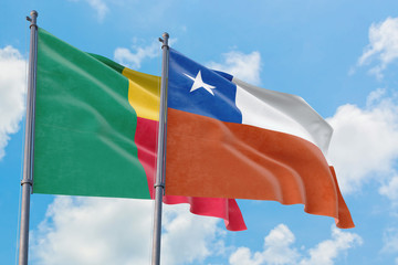 Chile and Benin flags waving in the wind against white cloudy blue sky together. Diplomacy concept, international relations.