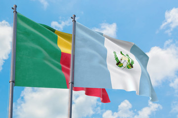 Guatemala and Benin flags waving in the wind against white cloudy blue sky together. Diplomacy concept, international relations.