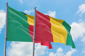 Guinea and Benin flags waving in the wind against white cloudy blue sky together. Diplomacy concept, international relations.