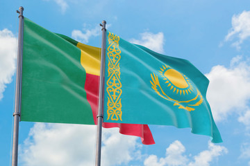 Kazakhstan and Benin flags waving in the wind against white cloudy blue sky together. Diplomacy concept, international relations.