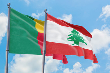 Lebanon and Benin flags waving in the wind against white cloudy blue sky together. Diplomacy...