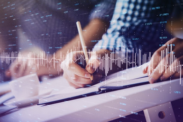 Multi exposure of two men planing investment with stock market forex chart.