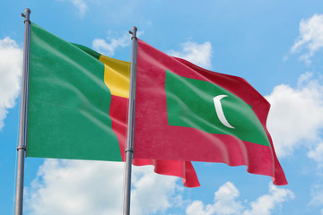 Maldives and Benin flags waving in the wind against white cloudy blue sky together. Diplomacy...