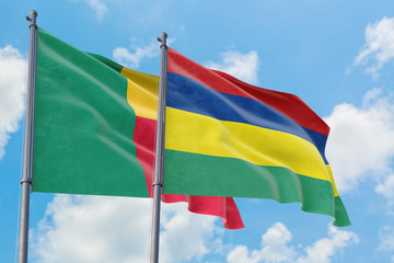 Mauritius and Benin flags waving in the wind against white cloudy blue sky together. Diplomacy concept, international relations.