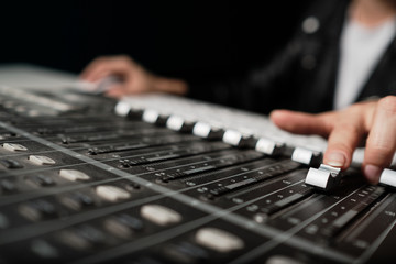 Female hands adjusting sound controller bars