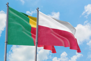 Poland and Benin flags waving in the wind against white cloudy blue sky together. Diplomacy concept, international relations.
