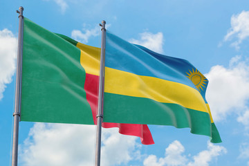 Rwanda and Benin flags waving in the wind against white cloudy blue sky together. Diplomacy concept, international relations.