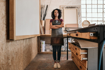 Smiling woman standing in her picture framing studio