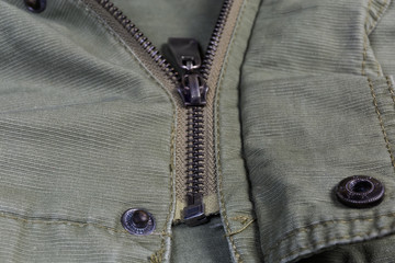Zipper and snap button fasteners on outerwear closeup, selective focus