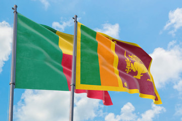 Sri Lanka and Benin flags waving in the wind against white cloudy blue sky together. Diplomacy concept, international relations.