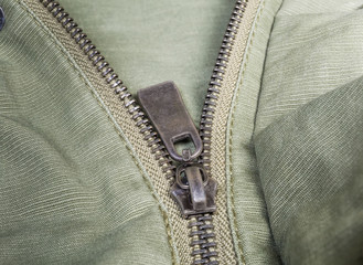Fragment of metal zipper on outerwear olive color close-up