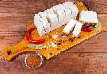 Pieces of salted pork fatback on cutting board among spice