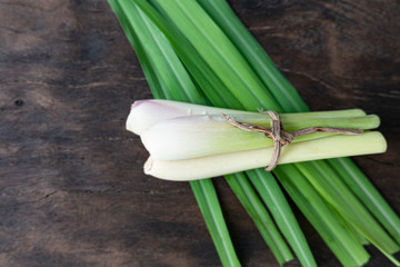 Fresh green lemongrass on dark cutting board.