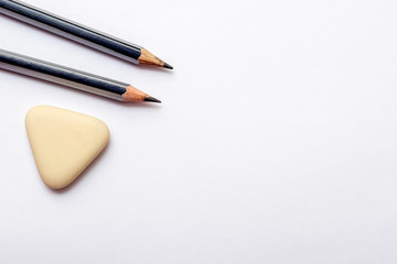 Pencils and eraser on white paper background. Copy space_