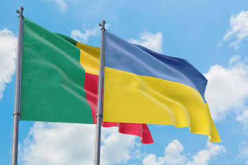 Ukraine and Benin flags waving in the wind against white cloudy blue sky together. Diplomacy concept, international relations.
