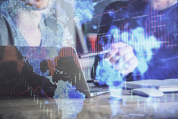 Fototapeta premium Forex graph with businessman typing on computer in office on background. Concept of analysis. Double exposure.