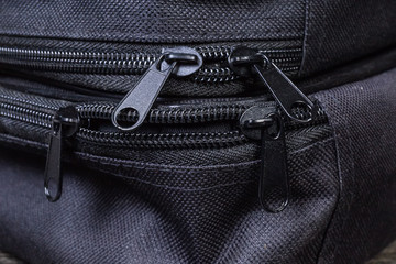 Metal sliders on plastic zippers on black bags close-up © An-T