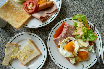 Breakfast. Bread, ham, sausage and fruit.