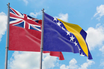 Bosnia Herzegovina and Bermuda flags waving in the wind against white cloudy blue sky together. Diplomacy concept, international relations.