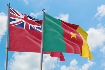 Cameroon and Bermuda flags waving in the wind against white cloudy blue sky together. Diplomacy concept, international relations.