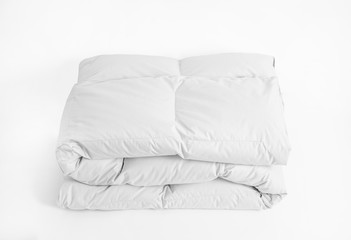Fototapeta na wymiar Folded soft white duvet, blanket or bedspread, against white background. Close up photo