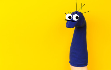 funny doll sock on yelow background, hand theater - Image