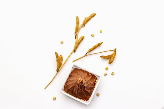 Light brown miso paste isolated on white background. Traditional Japanese seasoning, dry soya beans pods
