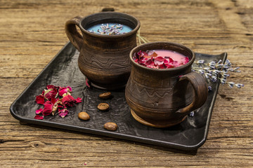 Set of romantic colored coffee latte for two lovers. Lavender and rose, powdered aromatic sugar, spices. Valentines Day concept. Wooden boards background