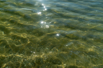 Sea texture of transparent water and pebbles