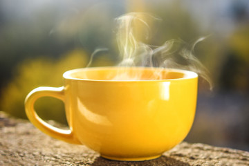 Yellow coffee or tea cup  with white steam 
