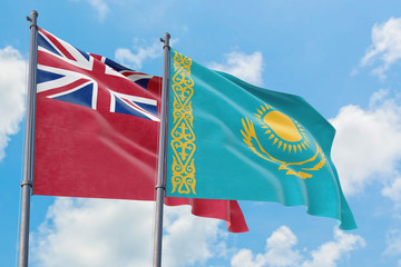 Kazakhstan and Bermuda flags waving in the wind against white cloudy blue sky together. Diplomacy concept, international relations.