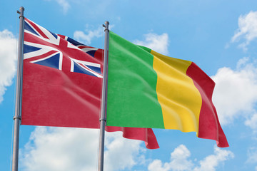 Mali and Bermuda flags waving in the wind against white cloudy blue sky together. Diplomacy concept, international relations.