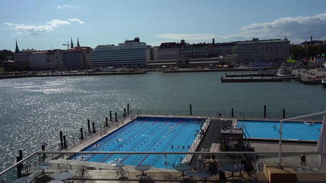 Helsinki, Finland 27.7.2019: Allas Sea Pool, Market Square, Presidental Palace and behind Helsinki Lutherdal Catetral . Suomenlinna ferry has just arrived at the beach. Sunny summer day in the capita