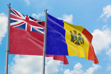 Moldova and Bermuda flags waving in the wind against white cloudy blue sky together. Diplomacy concept, international relations.