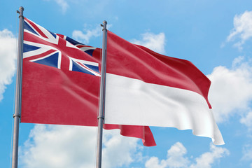 Monaco and Bermuda flags waving in the wind against white cloudy blue sky together. Diplomacy concept, international relations.