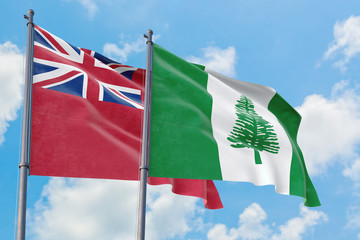 Norfolk Island and Bermuda flags waving in the wind against white cloudy blue sky together. Diplomacy concept, international relations.