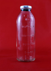 Empty medicine bottle. There is a scale for the amount of medicine on the bottle. On a red...