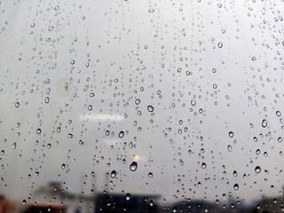 Water drops on glass, rain on a window background. drops of water-repellent surface in black &...