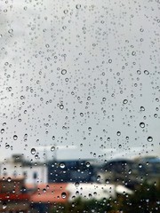 Water drops on glass, rain on a window background. drops of water-repellent surface in black &...