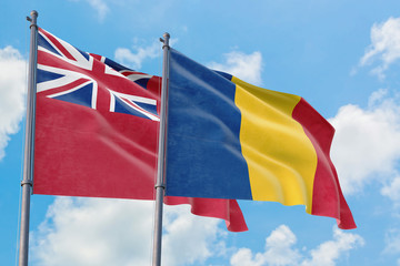 Romania and Bermuda flags waving in the wind against white cloudy blue sky together. Diplomacy concept, international relations.