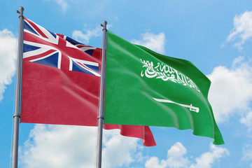 Saudi Arabia and Bermuda flags waving in the wind against white cloudy blue sky together. Diplomacy concept, international relations.