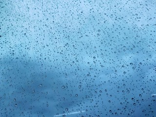 Water drops on glass, rain on a window background. drops of water-repellent surface in black &...