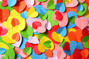 Fototapeta na wymiar Bunch of multicolored paper hearts cutouts background