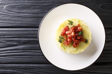 Mashed potatoes and green cabbage topped with fried bacon closeup in a plate. Horizontal top view