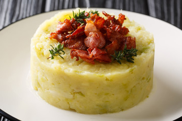 Trinxat Spanish and Andorran dish spicy mashed potato cabbage topped with fried bacon closeup in a plate. horizontal